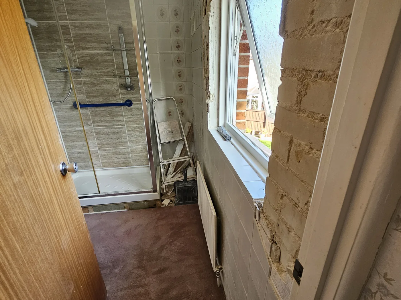 Bathroom stripped back, old tiles off and plaster hacked away round the window