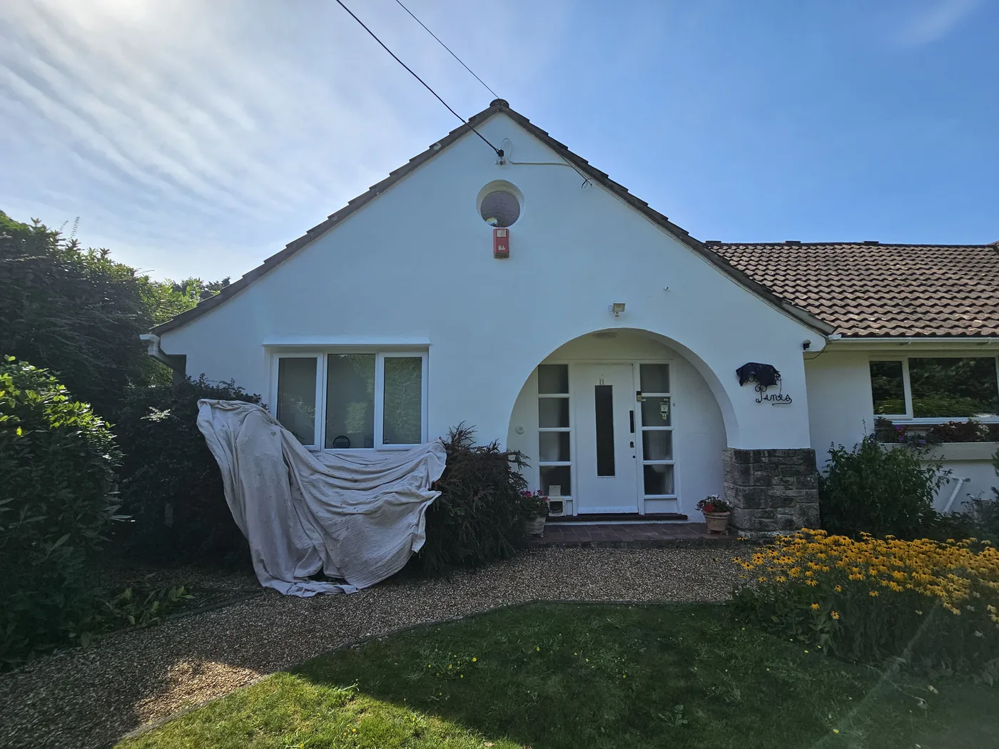 Bungalow exterior repainted white, arched porch and gable