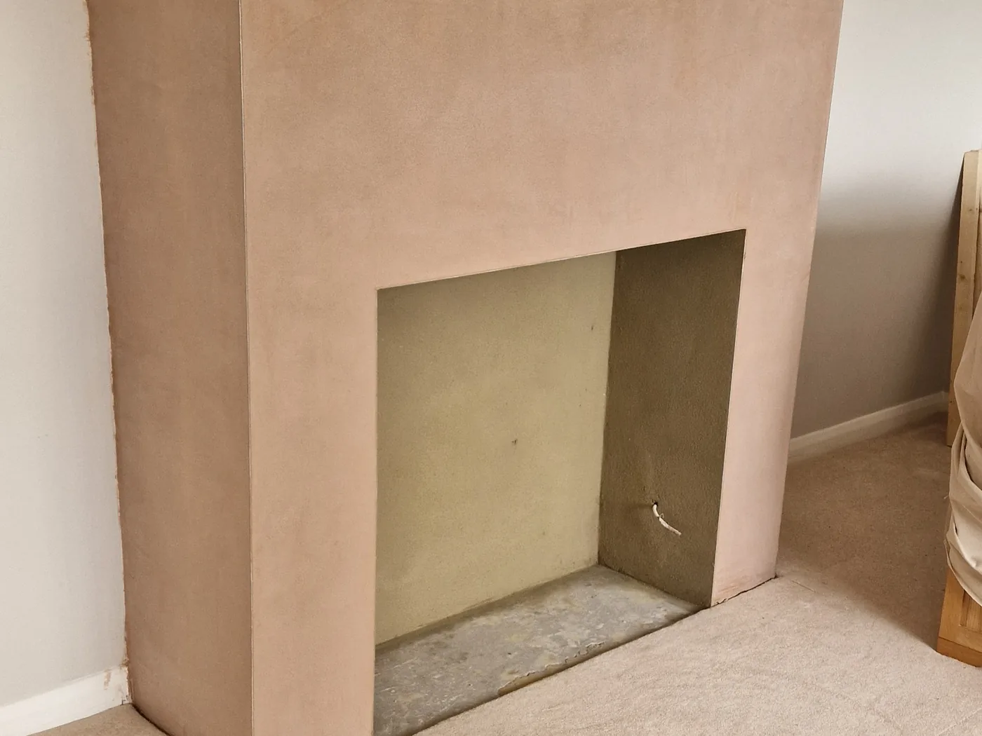 Chimney breast re-plastered with a square opening formed for a stove