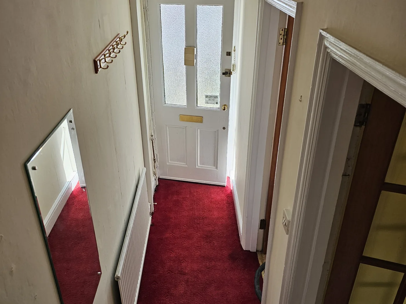 Finished hallway with fresh walls, white door frames and new paint to the front door