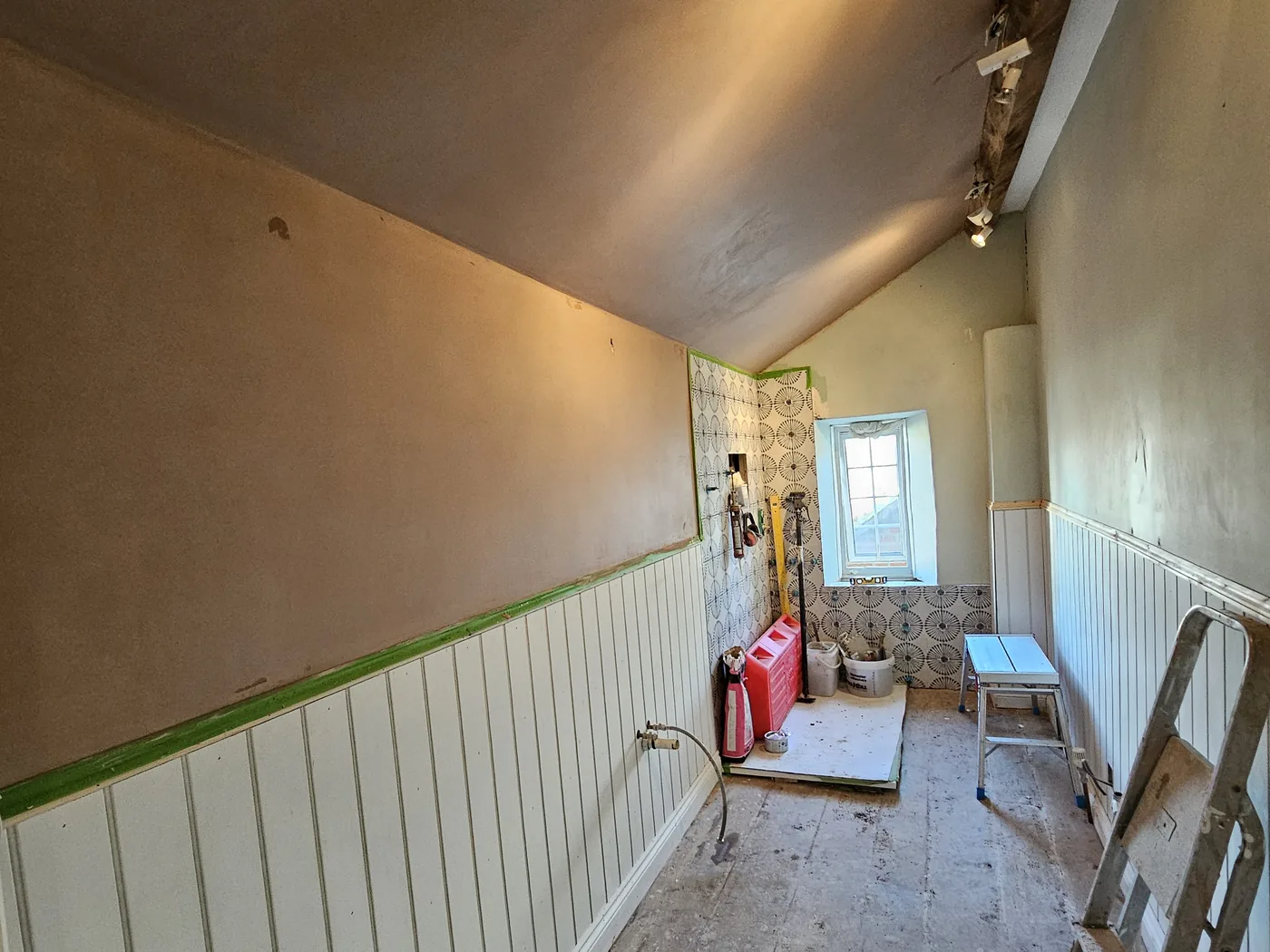 Loft room plastered over sloping ceilings and around an old beam