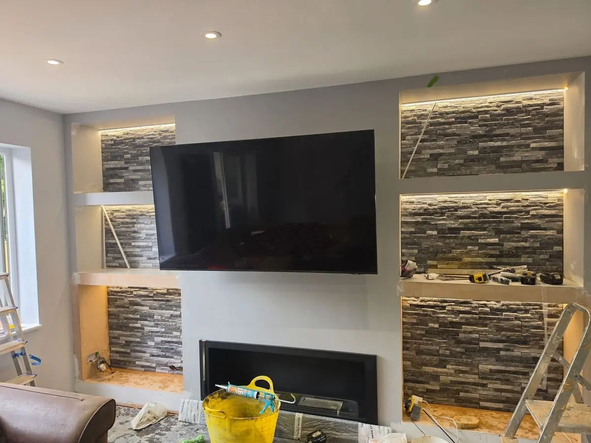 Media wall with stone-clad recesses and concealed lighting switched on