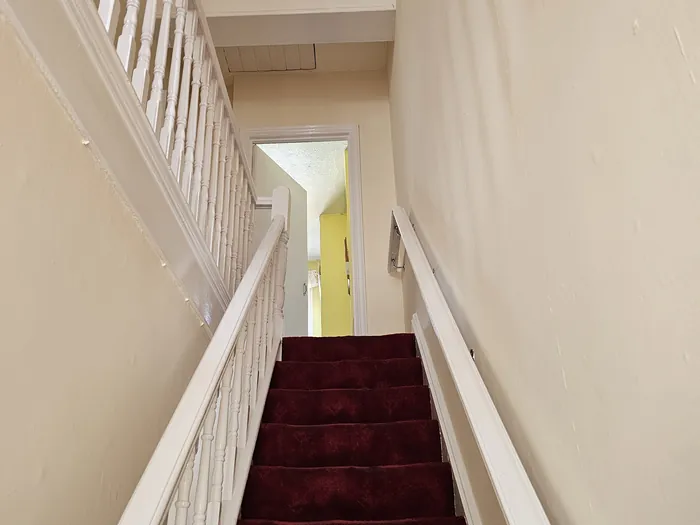 The finished stairwell with fresh walls, white spindles and handrail