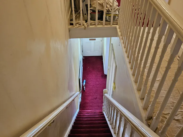 Stairwell walls filled and rubbed down ready for paint, carpet sheeted