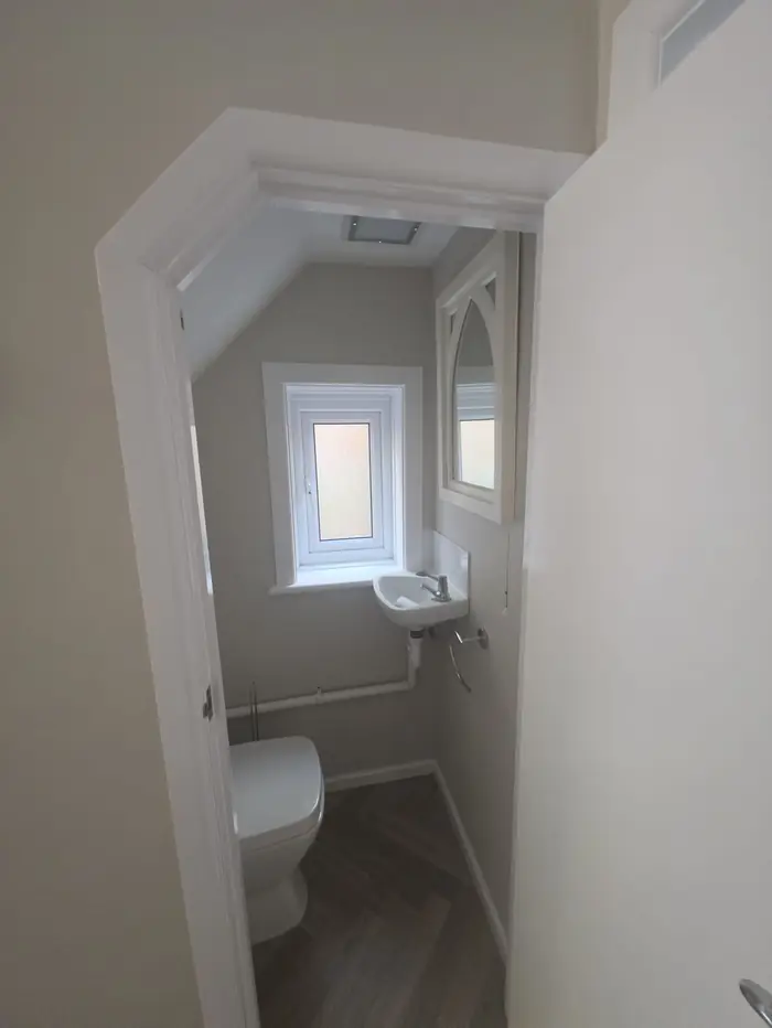 The same cloakroom redecorated in soft grey with white woodwork