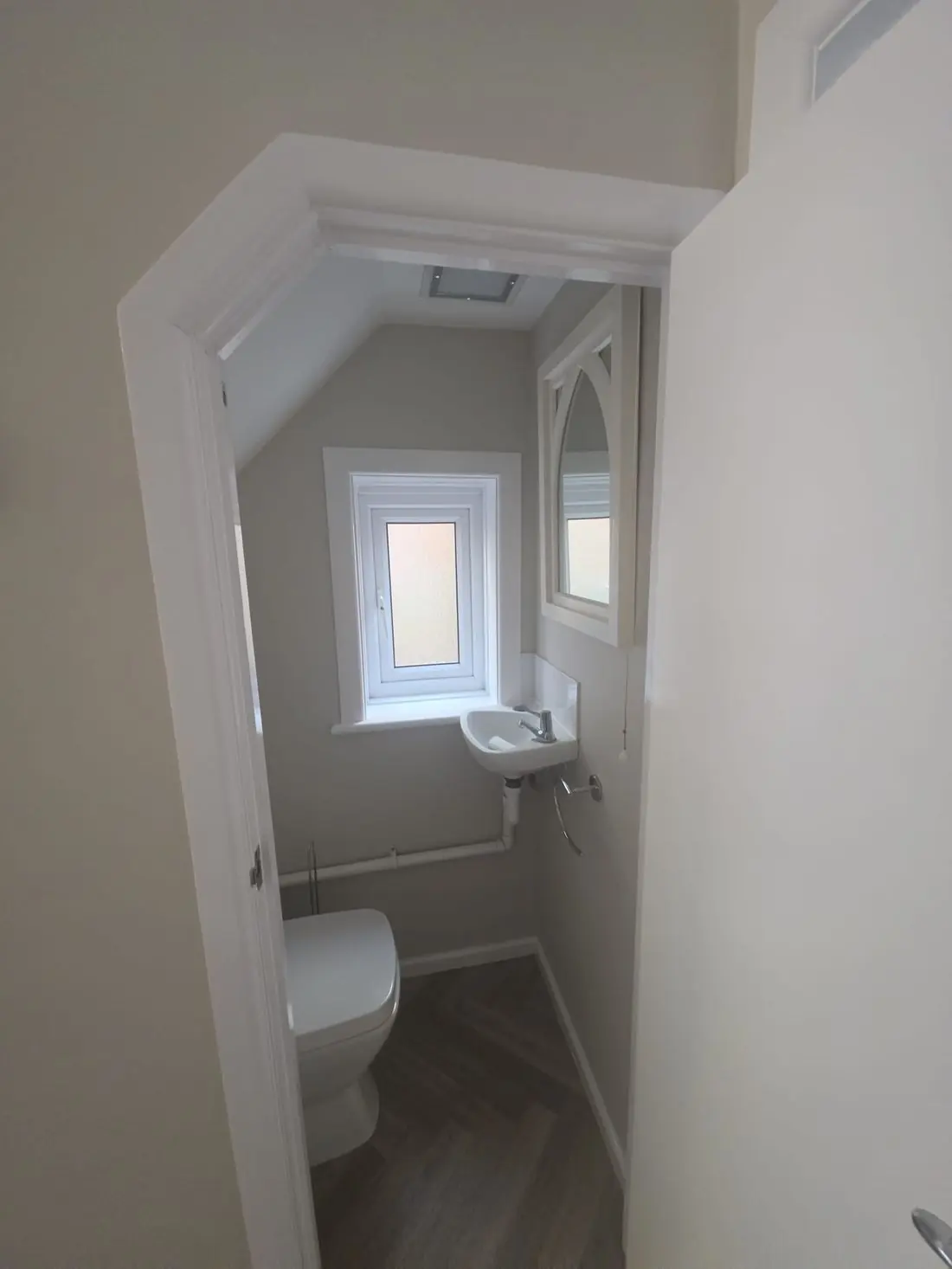 The same cloakroom redecorated in soft grey with white woodwork