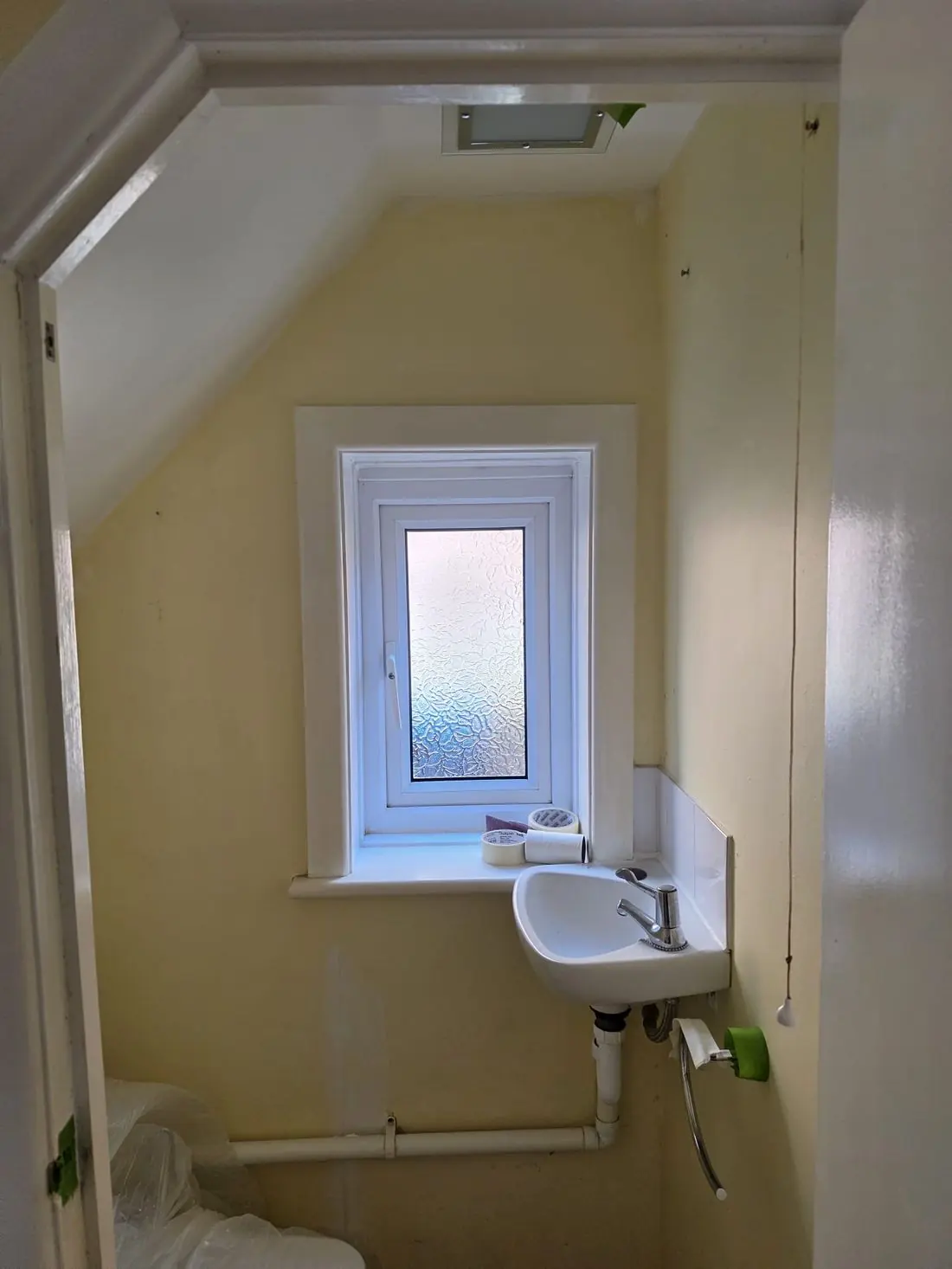 Downstairs cloakroom before decoration, in dated yellow paint